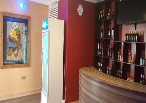 a room with a refrigerator and a shelf of wine bottles at Bethel Resort & Hotels in Gulu