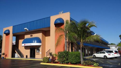a building with a car parked in a parking lot at Magnuson Hotel Bradenton in Bradenton