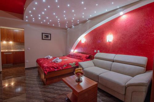 sala de estar con sofá y pared roja en Villa Dislievski, en Ohrid