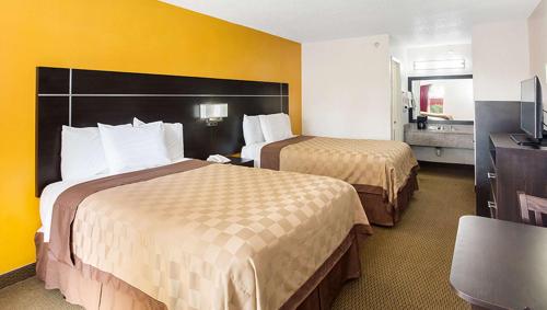a hotel room with two beds and a television at Magnuson Hotel Bradenton in Bradenton
