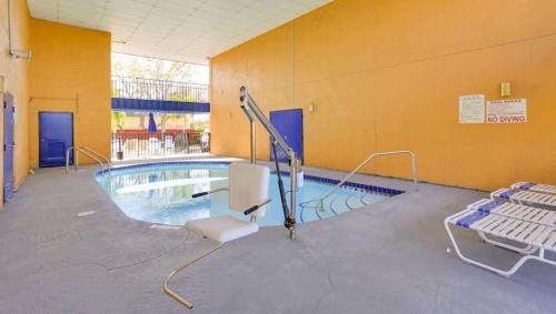 a swimming pool with a white chair and a pooliterator at Magnuson Hotel Bradenton in Bradenton
