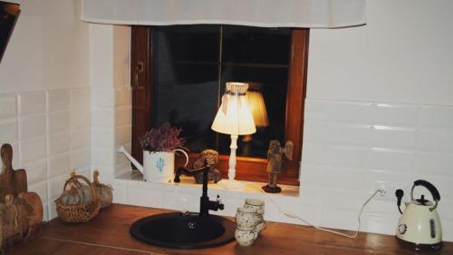 a table with a lamp in a kitchen with a window at Lawendowe Siedlisko in Suwałki