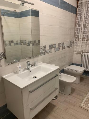 a bathroom with a sink and a toilet and a mirror at la casa del parco Ferrari in Modena