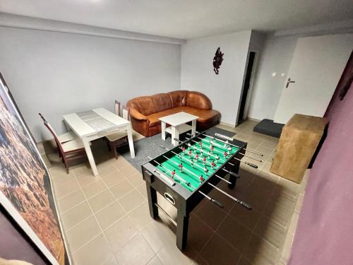 Willa Mała Beskidzka في فيسلا: غرفة معيشة مع طاولة كرة قدم وأريكة