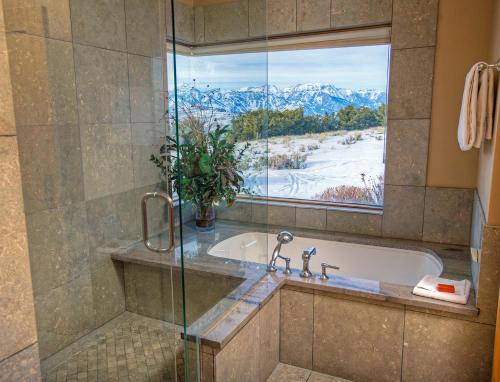 baño con bañera y ventana con vistas en Spring Creek Ranch, en Jackson