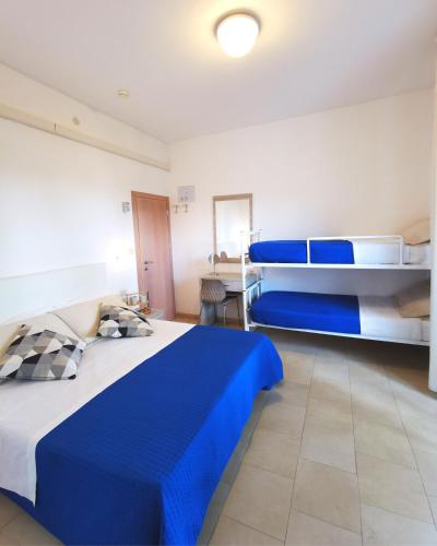 a bedroom with two bunk beds with blue sheets at Hotel Bellini in Riccione