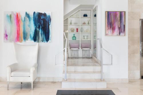 uma sala de estar com pinturas na parede e uma cadeira em YVE Hotel Miami em Miami