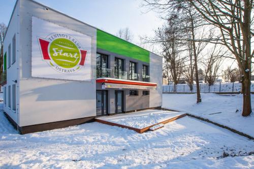 a building with a sign on it in the snow at Penzion Start Ostrava in Ostrava