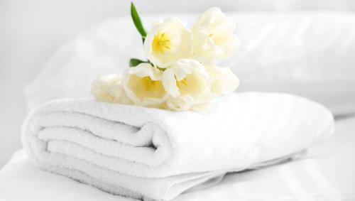 a towel with white flowers on top of it at Blue Mountain Motel in Okanogan