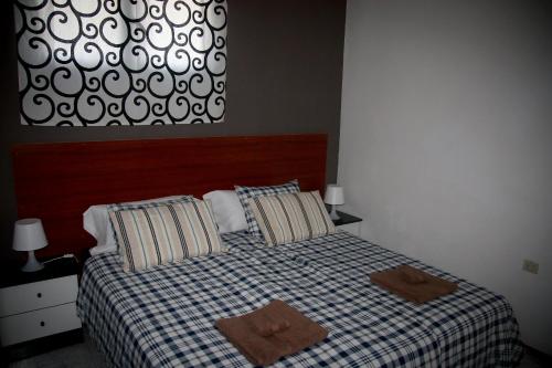 una camera da letto con un letto con due asciugamani sopra di Peñamar Apartamentos a Puerto del Carmen
