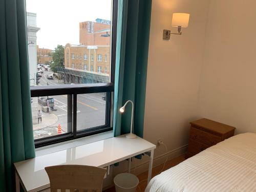 a bedroom with a desk and a large window at Chambres EL MEDITERRANEO Rooms in Montréal