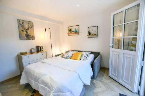 1 dormitorio con cama y ventana grande en Instant Fleury, studio cosy avec jardin secret, en Barbizon