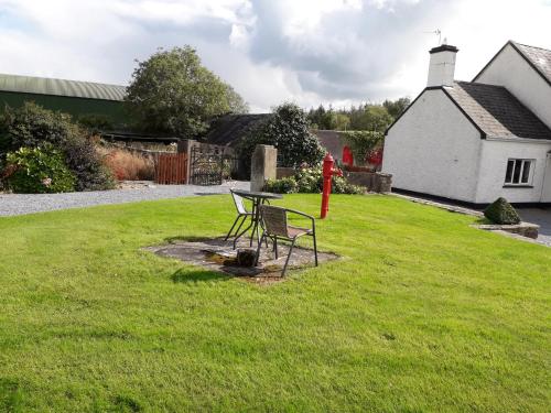 a table and chair in the yard of a house at Wellfield Farmhouse in Tipperary