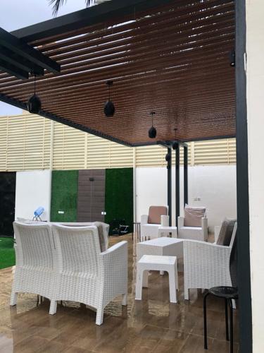 a dining room with white chairs and tables at شالية فاخر بمسبح خاص بمكة المكرمة in Makkah