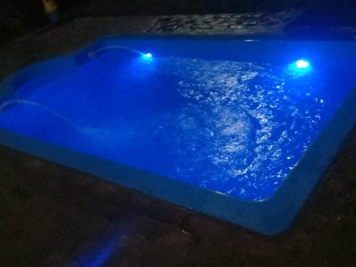 una piscina azul con luces en una habitación oscura en Alojamiento Casa en Pilar en Pilar