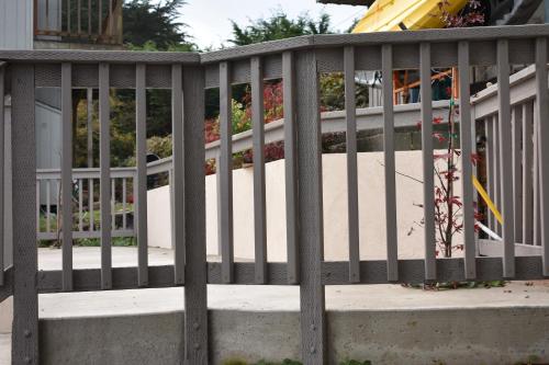 a metal railing on a porch with a walkway at Lighthouse Cove Inn in Bandon