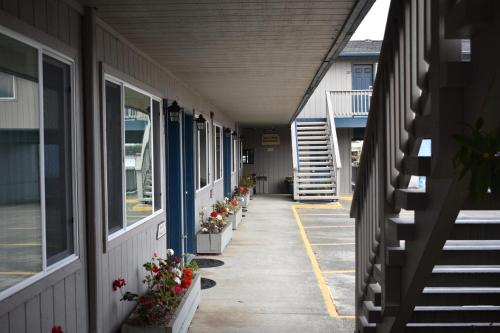 a hallway of a building with flowers inpots at Lighthouse Cove Inn in Bandon