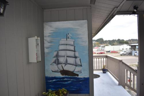 a painting of a ship on the side of a building at Lighthouse Cove Inn in Bandon