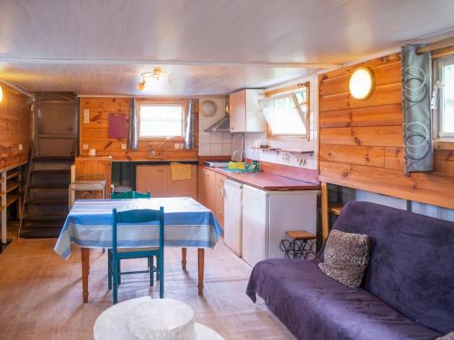 a living room with a couch and a table in a caravan at Comfy Houseboat in Florennes next to the Forest in Florennes