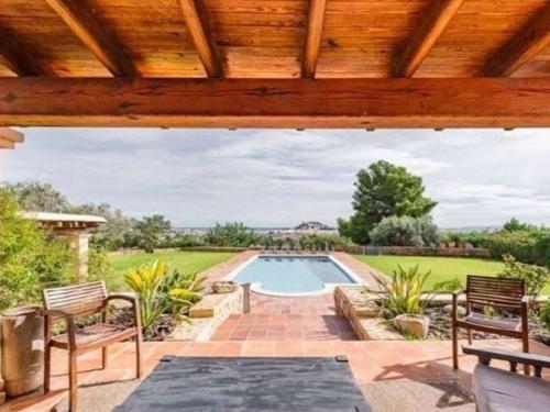 an outdoor patio with a pool and a wooden pergola at Tranquil Villa in Ibiza with Swimming Pool in Ibiza Town
