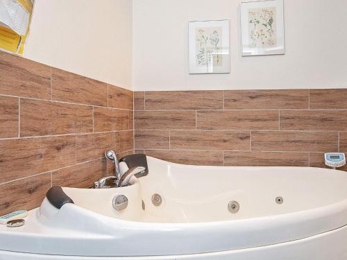 a bath tub in a bathroom with wooden tiles at 6 person holiday home in V ggerl se in Marielyst