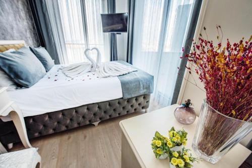 a bedroom with a bed and a table with flowers on it at Pera Life in Istanbul