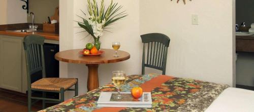 a table with a bowl of fruit and two glasses of wine at Hotel California in Palm Springs