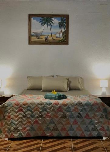 a bedroom with a bed with a painting on the wall at Casa à beira do rio Jaguareguava na Mata Atlântica em Bertioga SP in Bertioga