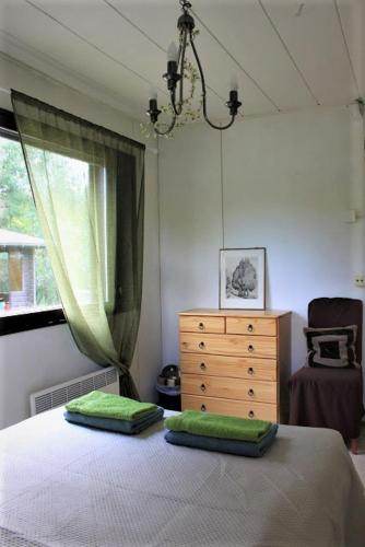 ein Schlafzimmer mit einem Bett, einer Kommode und einem Fenster in der Unterkunft Your Hotels in Nuppola