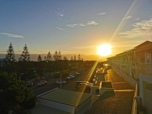 a sunset over a street with a parking lot at Salt - 2brm apartment with Spa bath and Ocean Views in Kingscliff