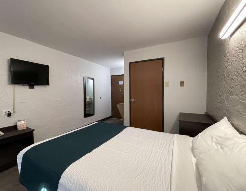 a hotel room with a bed and a flat screen tv at Motel 6-Green Bay, WI - Lambeau in Green Bay