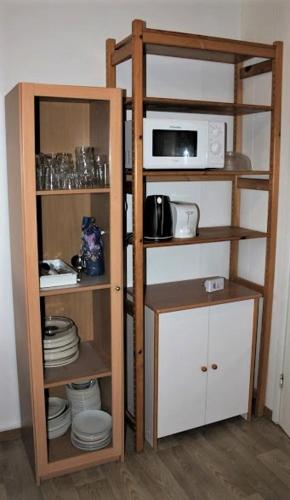 eine Küche mit Mikrowelle und einem Regal mit Geschirr in der Unterkunft Your Hotels in Nuppola