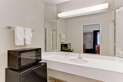 a bathroom with a sink and a microwave at Days Inn by Wyndham Tucson City Center in Tucson