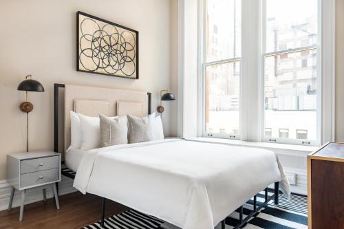 Un dormitorio con una gran cama blanca y una ventana en Sonder Jewelers Row, en Chicago