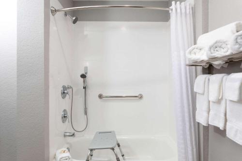 a bathroom with a shower and a toilet and towels at La Quinta by Wyndham Tampa Central in Tampa