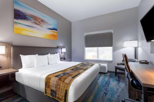 a hotel room with a large bed and a desk at La Quinta by Wyndham Tampa Central in Tampa
