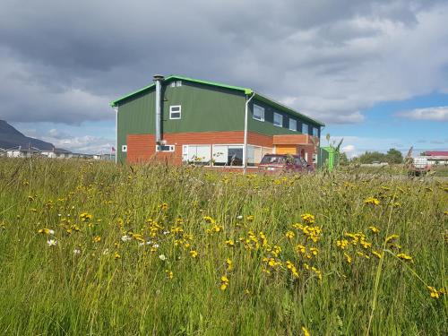 a house in a field of grass and flowers at Hotel Casa Verde in Puerto Natales