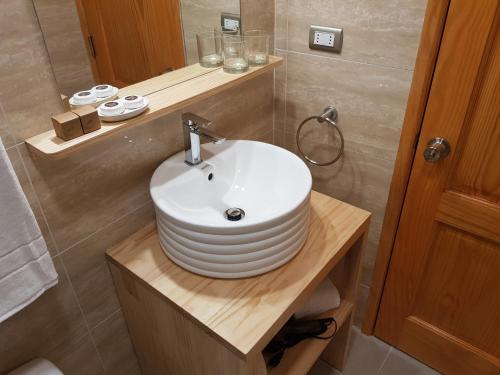 un bagno con lavandino bianco su un bancone in legno di Hotel Casa Verde a Puerto Natales