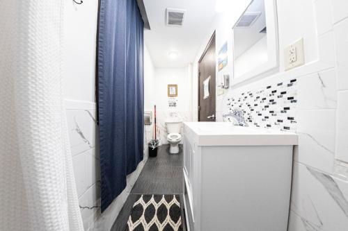 een badkamer met een witte wastafel en een toilet bij Shefah Hotel in Union City