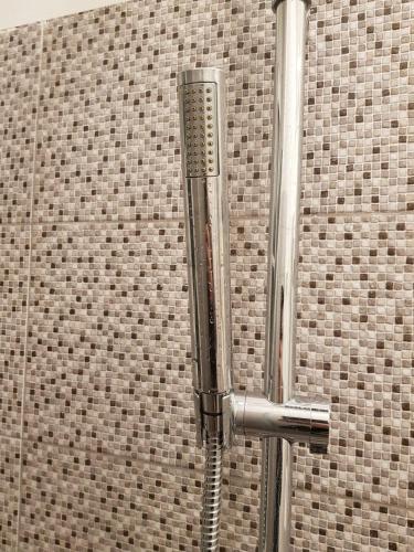 a shower head in front of a brick wall at Rainbow Guest House in Lisbon