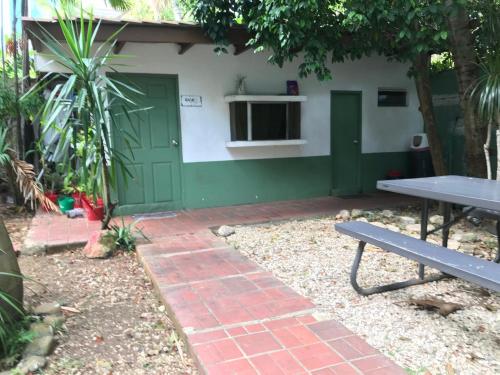 a green door and a picnic table in front of a building at CulturaHumana Guesthouse in Panama City