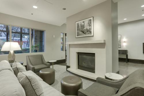 a living room with a couch and a fireplace at Renu Suites at The Burlington Portland in Portland