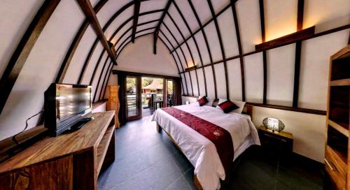 1 dormitorio con 1 cama y TV. en Oceans 5 Dive Resort en Gili Air