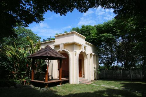 a small white house with an umbrella in a yard at Dream Home B&B in Hualien City