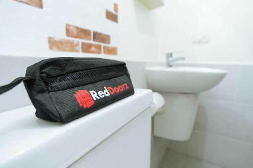 un sac noir assis sur un comptoir dans une salle de bains dans l'établissement RedDoorz Plus @ Vantas Hotel Parbaba, à Sinapuran