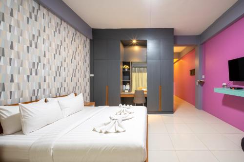 The Iconic Hotel Ranong tesisinde bir odada yatak veya yataklar