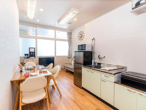 a kitchen and dining room with a table and chairs at El Sol Town Okinawa in Chatan