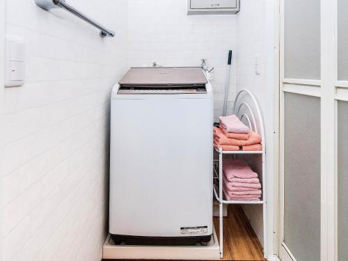a small white refrigerator in a laundry room at El Sol Town Okinawa in Chatan