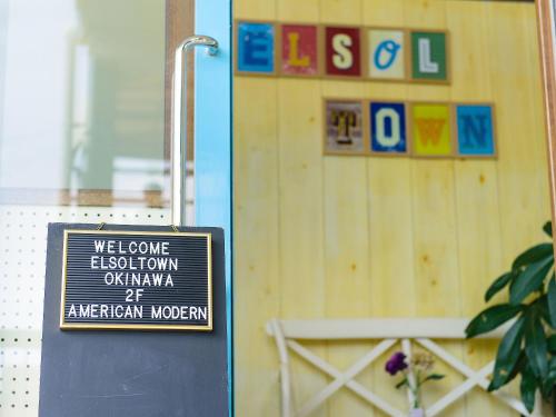 a sign in front of a wooden wall at El Sol Town Okinawa in Chatan