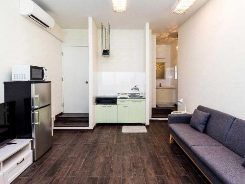 a living room with a couch and a kitchen at El Sol Town Okinawa in Chatan